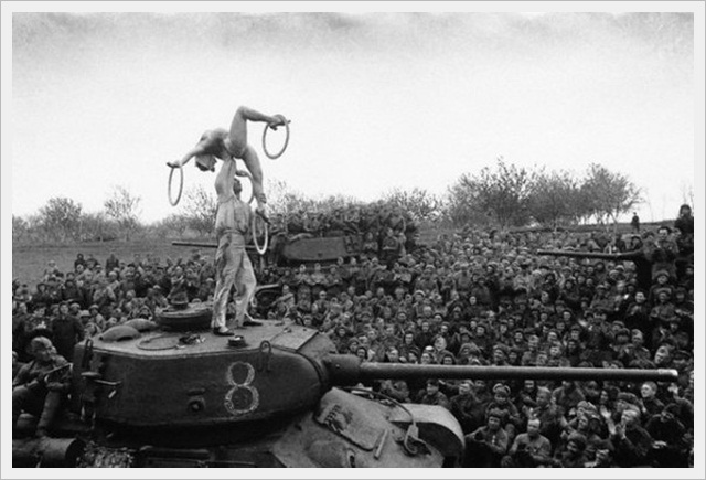 Soviet soldiers take a break to watch an acrobatic show on the march towards Berlin (1945)